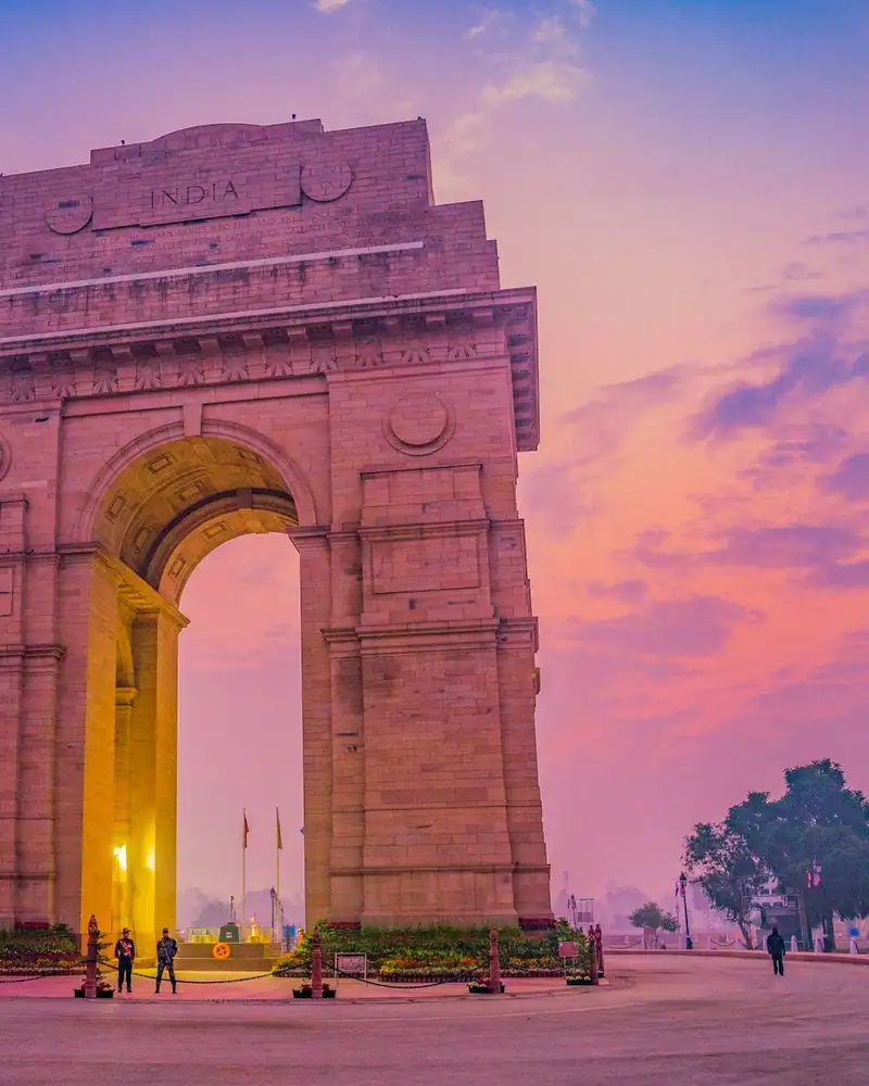 India Gate, New Delhi, at dusk under a pink sky
