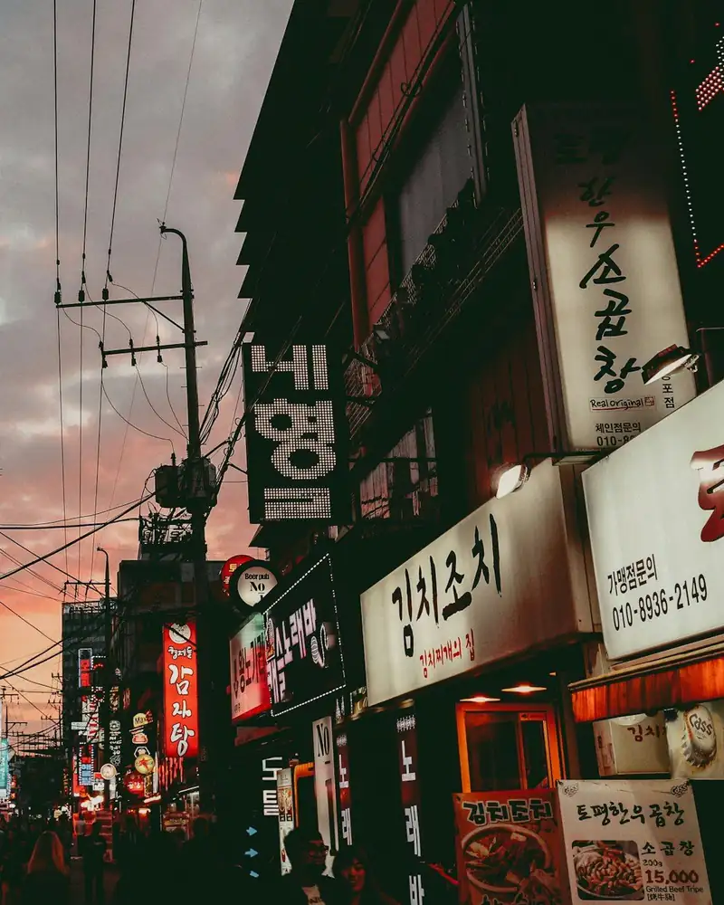 Neon shop signs on a busy Seoul street
