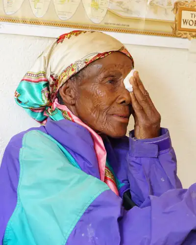 Elderly woman the day after cataract surgery, gesturing as she describes her sight
